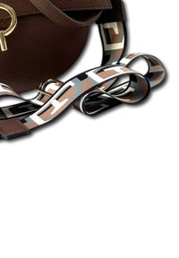 Bruine leren handtas in een ronde vorm. Uitrusting met een gestreepte schouderriem in beige, bruin, zwart en wit met geometrische patronen en gouden hardware.