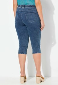 Blå denim capri-byxor med en bekväm elastisk midja, med en figurnära design och sydda detaljer vid anklarna.