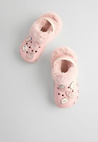 Sabots roses en peluche avec une doublure douce en fourrure, ornés de breloques décoratives et de trous de ventilation. Forme arrondie et sangle ajustable pour un bon maintien.