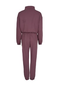Ensemble composé d'un sweat-shirt bordeaux à manches longues et d'un pantalon de jogging assorti avec des poignets et une taille élastiques, vu de dos.