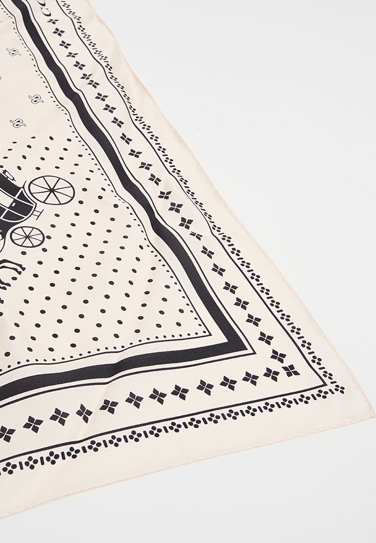 Foulard en soie avec un fond beige parsemé de pois noirs et un motif de bordure, comprenant des motifs complexes et des accents graphiques de chariots.