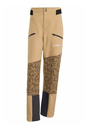 Beige sportieve broek met een patroon in bruine onderste panelen, zwarte accenten en ritszakken. Voorzien van een drukknoopsluiting en een verstelbare tailleband.