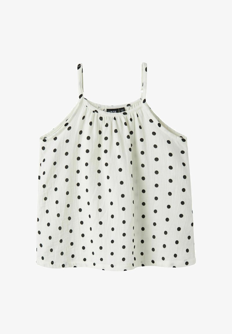 Blouse blanche sans manches avec fines bretelles et motif à pois noirs, à coupe ample et fluide.