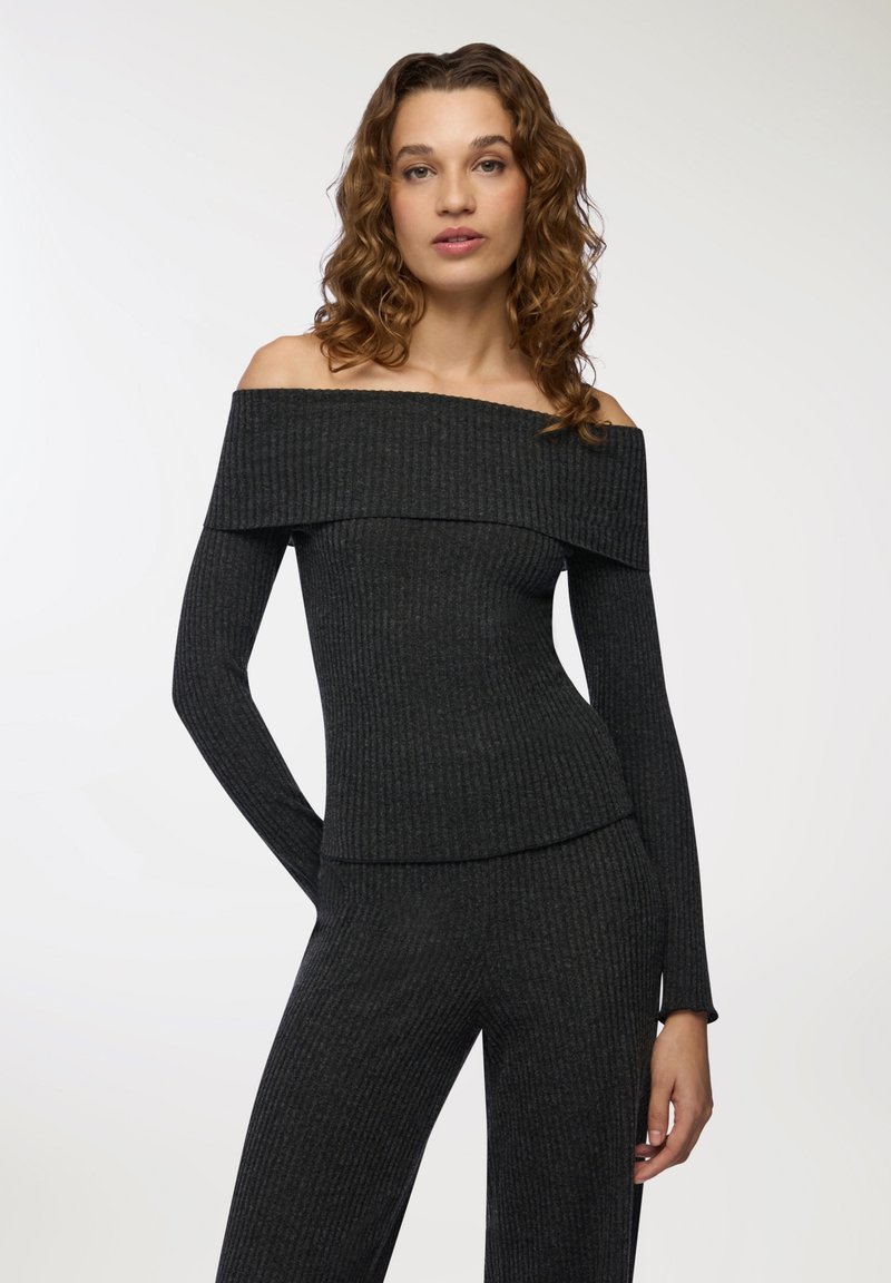 Top typu off-shoulder, prążkowany w ciemnoszarym kolorze z długimi rękawami, z szerokim dekoltem i dopasowanym krojem. Miękka tekstura, minimalne detale.