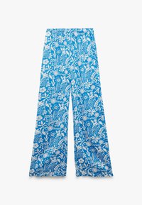 Niebieskie spodnie typu wide-leg mają biały kwiatowy wzór, elastyczny pas oraz lekką tkaninę o gładkiej fakturze.