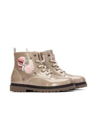 Botas de tobillo doradas brillantes con punta redonda, diseño de cordones y parches decorativos que incluyen estrellas, un unicornio y pompones.