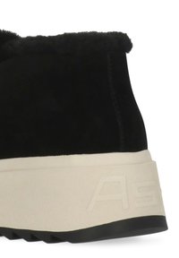 Stivaletto nero in suede con tomaia testurizzata, suola intermedia color crema e suola esterna in gomma nera. Logo in rilievo ben visibile sul lato.