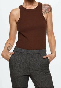 Canotta marrone a coste con scollo rotondo abbinata a pantaloni a quadri grigi texturizzati. Caratterizzata da una vestibilità rilassata con tasche.