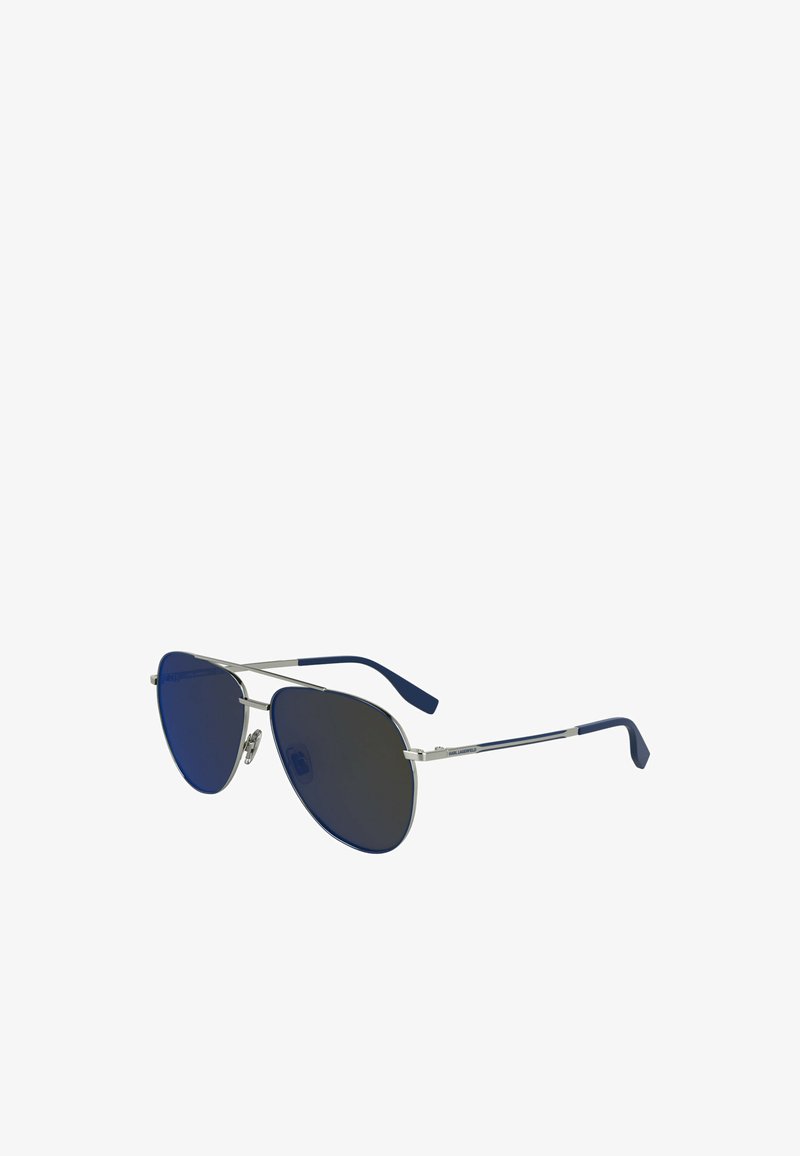 Okulary przeciwsłoneczne aviator z metalową srebrną oprawką, ciemnoniebieskimi soczewkami i granatowymi kauczukowymi końcówkami zauszników. Charakteryzują się eleganckim, kanciastym designem.