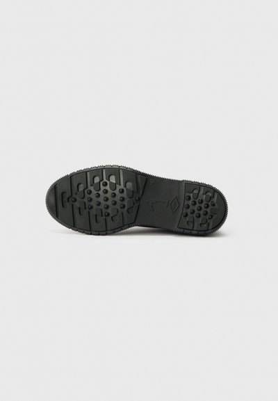 Semelle de chaussure en caoutchouc noir avec une surface texturée, présentant des motifs circulaires et rectangulaires pour une meilleure adhérence, et un bord décoré pour la durabilité.