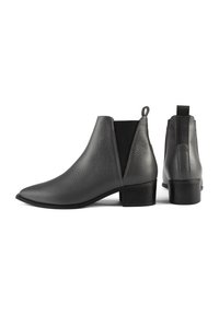 Botas de cuero negras hasta el tobillo con punta afilada, paneles laterales elásticos y un acabado texturizado; cuentan con un pequeño tacón y una lengüeta para tirar.
