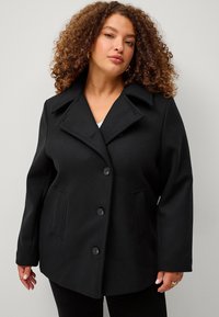 Cappotto in misto lana nera con design strutturato, ampio colletto a bavero, quattro bottoni e due tasche frontali. Texture morbida e vestibilità su misura.