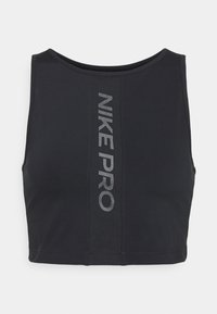 Brassière de sport noire coupée, fabriquée en tissu extensible. Présente un col rond et le texte "NIKE PRO" imprimé en gris réfléchissant sur le devant. Texture lisse.