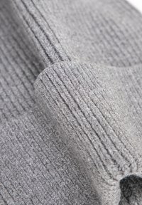 Tessuto grigio con texture a coste, caratterizzato da fibre morbide. Il materiale è spesso e caldo, con sottili variazioni di tonalità.