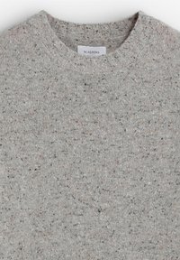 Lichtgrijze gebreide trui met ronde hals, met een gestructureerde textuur in donkere tinten en een label met de tekst "SCALPERS" op de hals.