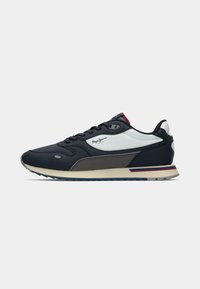 Marineblå og hvite joggesko med teksturert overdel, snøring, og en kontrastfarget beige såle med røde og blå detaljer.