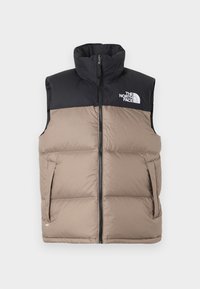 Melns un bēšs pūkains vests ar augstu apkakli, rāvējslēdzēja aizdari un sānu kabatām. Augšējā kreisajā pusē ir "The North Face" logo.