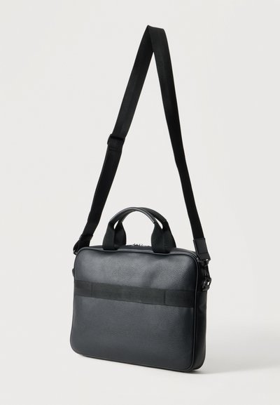 Sac bandoulière rectangulaire noir avec deux courtes poignées, une longue bandoulière réglable, une fermeture zippée et une bande horizontale en sangle sur le devant.