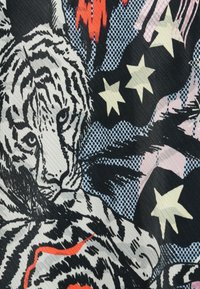 Vzorkovaná látka s obrazcom sivého a čierneho tigra na modrom pozadí s červenými tvarmi a žltými hviezdami, vytvárajúca výrazný, grafický dizajn.