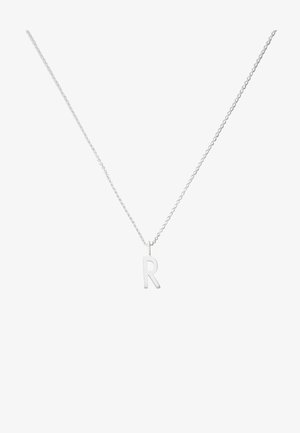 Sølv halskæde med et pendants af stort bogstav "R". Kæden er fin og delikat, hvilket komplementerer den minimalistiske design af bogstavet.