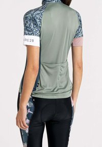 Kortärmad träningsöverdel i olivgrönt med mönstrad ok och vita detaljer, kombinerad med svarta leggings med en blommig sidopanel.