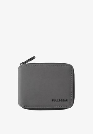 Graue rechteckige Zippetui mit abgerundeten Kanten, sichtbarer Naht und "PULL&BEAR"-Logo, das in der unteren rechten Ecke geprägt ist.