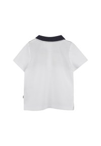 Witte korte mouwen polo met een marineblauwe kraag. Gladde textuur en neutraal ontwerp, met een zijkraaglabel nabij de zoom.