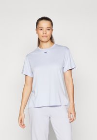 Ljuslila t-shirt med kort ärm, tillverkad av mjukt och slätt tyg, med rundhals och en liten mörkblå Puma-logotyp broderad på bröstet.