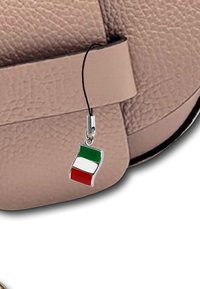Zilveren charme van een Italiaanse vlag met groene, witte en rode secties, vastgemaakt aan een beige, gestructureerde handtas met een platte schouderband.