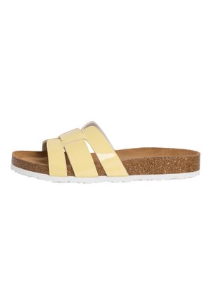 Żółta sandałka na płaskiej podeszwie z trzema błyszczącymi paskami, korkową wkładką i białą, fakturowaną podeszwą, pokazana z boku na białym tle.