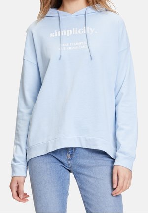 Světle modrá mikina s tkaničkami nošená s modrými džínami, na hrudi s bílým nápisem „simplicity.“