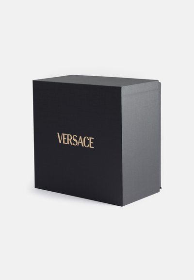 Scatola nera con finitura texturizzata, dotata di lettering dorato "VERSACE" sul davanti. Design elegante e rettangolare con un aspetto minimalista.