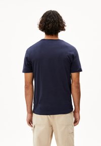 T-shirt in cotone blu navy con scollatura rotonda e maniche corte, caratterizzato da un design semplice senza grafiche o motivi visibili.