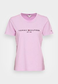 Rosa bomull t-shirt med rund hals, korta ärmar och svart "TOMMY HILFIGER EST. 1985" logotyp på framsidan. Liten logotyp på ärmen.