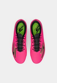 Λαμπερά ροζ αθλητικά παπούτσια Skechers με μαύρες κορδόνες και φωσφορίζουσες πράσινες σόλες, απεικονιζόμενα από πάνω σε λευκό φόντο.