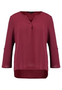 Blouse rouge foncé à manches longues avec encolure en V avec entaille, ourlet arrière légèrement plus long et détails de boutons sur les manches.