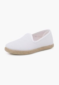 Scarpe bianche slip-on con tomaia in tessuto testurizzato e suola in juta intrecciata. Profilo basso con punta arrotondata e dettagli di cucitura minimi.