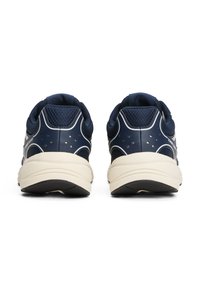 Morskie buty sportowe z siateczkowymi i syntetycznymi materiałami, zaokrąglonym tyłem, kremowymi podeszwami i białymi akcentami z małymi perforacjami.