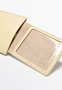 Beige leren portemonnee met een gladde buitenkant en een zachte, met vilt gevoerde binnenkant. Voorzien van een helder venster voor een ID, gestikte randen en een minimalistisch ontwerp.