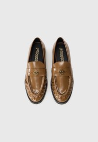 Une paire de mocassins en cuir marron avec des détails froncés et un emblème doré sur la sangle, des semelles noires et la marque "PINKO" à l'intérieur.