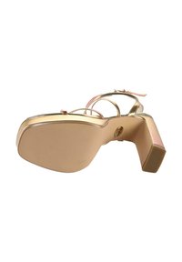 Auksinės aukštakulnės sandalai su plačiu pagrindu, plonais dirželiais ir lygiu paviršiumi. Kulnas yra tvirtos kvadratinės formos su rožiniu akcentu.