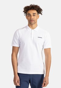 Valkoinen poolopaita, jossa on lyhyet hihat, kaulus ja nappilista. Vasemmassa rinnassa on pieni musta "ROSSIGNOL" -logo.