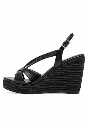 Sandales compensées noires en cuir synthétique à texture de crocodile, dotées d'un design à brides croisées et d'une boucle réglable à la cheville.