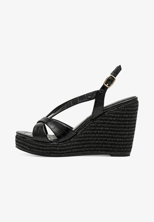Sandales compensées noires en cuir synthétique à texture de crocodile, dotées d'un design à brides croisées et d'une boucle réglable à la cheville.