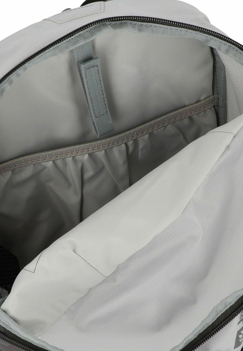 Hellgrauer Rucksack-Innenraum, der ein gepolstertes Fach mit elastischem oberen Rand und einem Gurt zur Sicherung eines Laptops oder Tablets zeigt.