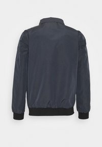 Blouson aviateur bleu marine foncé, en tissu lisse, avec manches longues, col, et poignets et ourlet côtelés. Design simple et épuré.