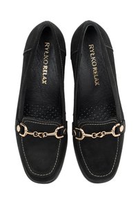 Mocasines de ante negros con un acento de cadena dorada, punta redondeada y detalles de costura visibles. Interior suave y texturizado con perforaciones.