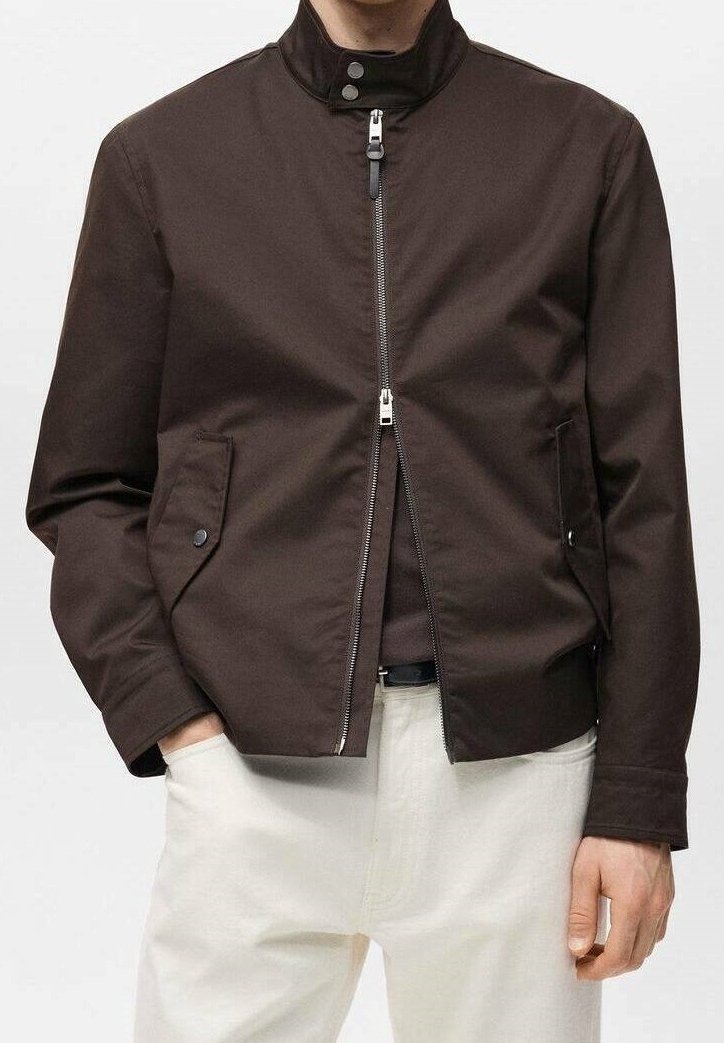 Braune Jacke mit Reißverschluss und Stehkragen, ausgestattet mit Seitentaschen und silbernen Metallakzenten. Hergestellt aus glattem, robustem Stoff.