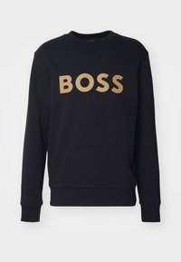 Sudadera negra de cuello redondo con mangas largas, que presenta la palabra "BOSS" en letras grandes y en negrita de color beige en el pecho.
