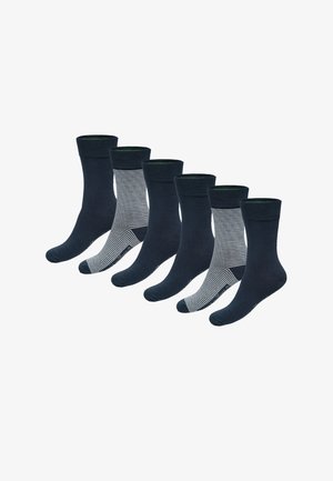 Six chaussettes bleu marine, dont deux paires présentant des rayures horizontales blanches et bleu marine, disposées en rangée décalée sur fond blanc.